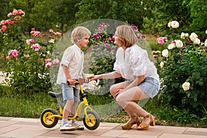 Mom and son walk in flower garden