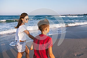 Mom and son walking and playing on the beach