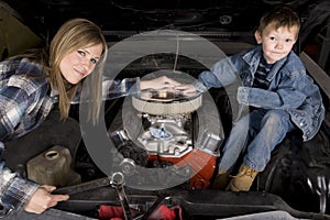 Mom and son working on car