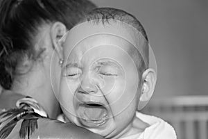 Mom soothes baby. The baby is crying