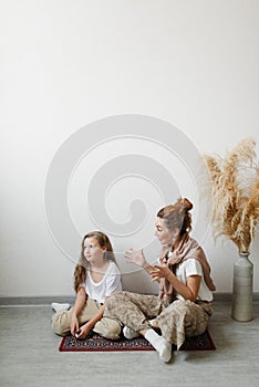 Mom swears at her naughty daughter at home sitting on the floor