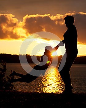 Mom Swings Son in Sunset