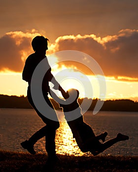 Mom Swings Son in Sunset