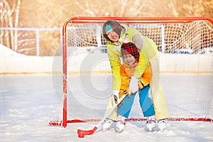 Mom teach boy to play ice hockey