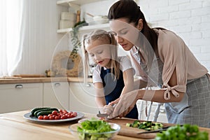 Mom teach little daughter cooking in kitchen