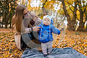 Mom teaches the kid to walk. .Young mother walks in the park with baby.