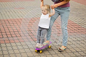 Mom teaches a little girl to skate. Hilarious pastime