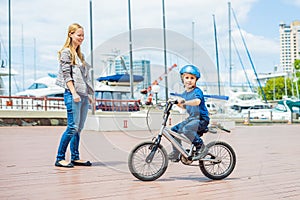 Mom teaches son to ride a bike in the park