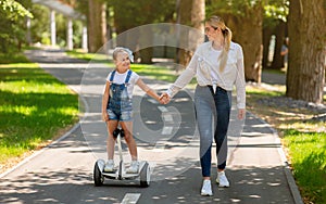 Mom Teaching Little Daughter To Ride Segway In Park