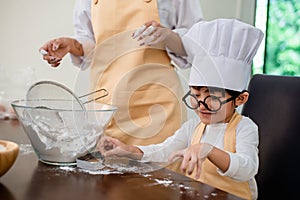 Mom teaching son for cooking food. Mother and kid daily lifestyle at home. Asian family together