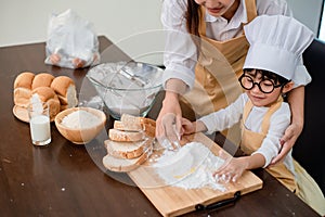 Mom teaching son for cooking food. Mother and kid daily lifestyle at home. Asian family together