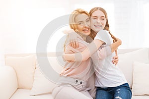 Mom and teenage daughter embrace.