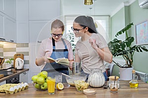 Mom and teenage daughter preparing apple pie in kitchen together