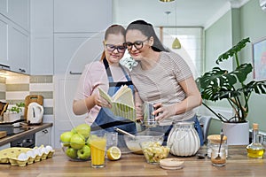 Mom and teenage daughter preparing apple pie in kitchen together