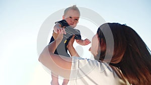 Mom throws up baby son play in the park. mother day kid dream childhood happy family concept. mum parent playing on