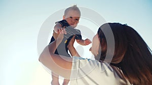 Mom throws up baby son play in the park. mother day kid dream childhood happy family concept. mum parent playing on