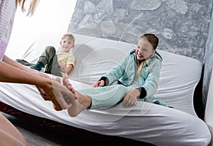 Mom tickles her daughter`s feet. A teenage girl laughs.