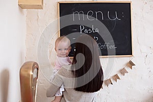 Mom and Toddler Daughter playing menu planning write to blackboard and chalk,