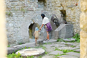 Mom with toddler observing broken iron mill gear in Dolsky mill