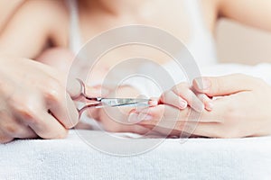 Mom tonsured nails on the hands newborn using nail scissors