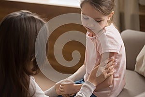 Mom touch caress unhappy preschooler daughter sitting on couch