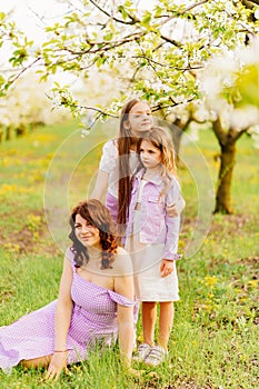 mom and two daughters. A family in a blossoming spring garden.