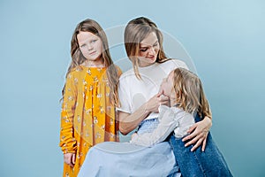 Mom and two daughters socialize together on a blue background