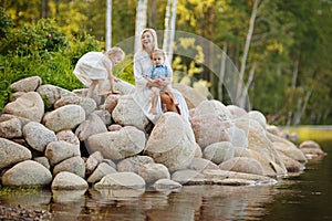 Mom in a white dress with her son and daughter sitting on large