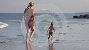 Mom worries about her son and tells him about poisonous jellyfish walking along the beach strewn with jellyfish