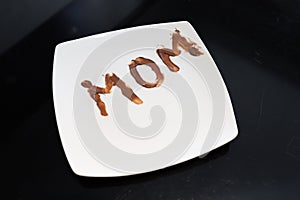 Mom Written on a Plate with Chocolate Spread by a Little Girl