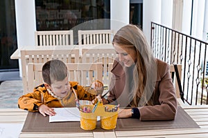 Mom and young boy draw colored pencils