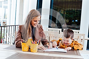 Mom and young boy draw colored pencils