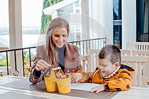 Mom and young boy draw colored pencils