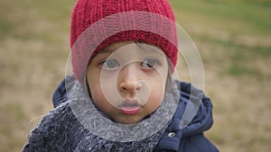 Mom zips up her son`s jacket on the street