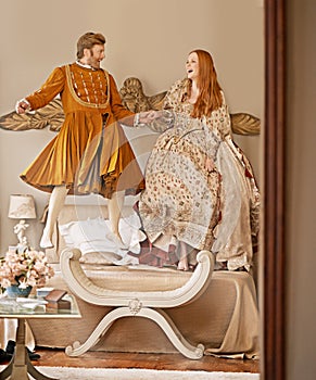 A moment of frivolity. a highborn couple enjoying a moment of frivolity in their bedroom. photo