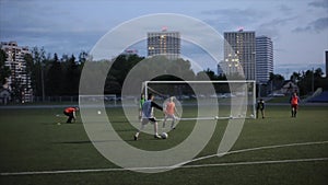 The moment of the goal at the game training of the football team against the backdrop of the evening city. Slow-motion