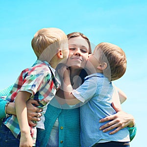 Moment of happy mother! Portrait family two children sons kissing mom