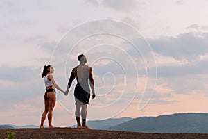 Moment of harmony. Happy mixed race couple athlethic caucasian woman with african american bodybuilde holding hands and