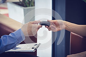 The moment that her waiting. Car salesman giving a car key to attractive Asian millennial girl at car dealership office. Film tone