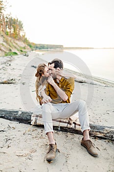 A moment before a kiss. Young couple is having fun and hugging on the beach. Beautiful girl embrace her boyfriend from