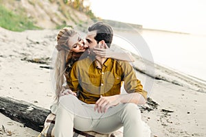 A moment before a kiss. Young couple is having fun and hugging on the beach. Beautiful girl embrace her boyfriend from