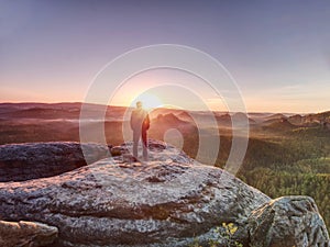 Moment of loneliness. Man with hands in pockets on the rock