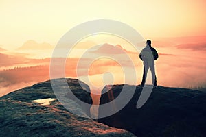 Moment of loneliness. Man on the rock empires and watch over the misty and foggy morning valley to Sun photo