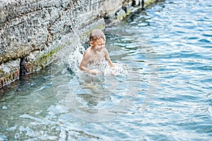 Moment of small boy diving into water while jumping in sea