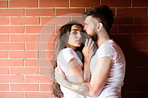 Moments of intimacy. Couple in love hugs brick wall background. Couple find place to be alone. Girl and hipster romantic