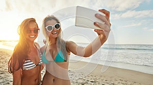 Moments to be remembered. two friends taking selfies while hanging out at the beach.