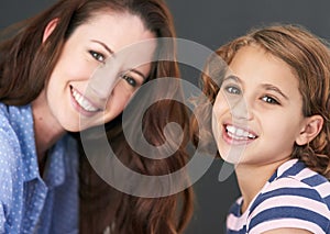 Mommy, girl and portrait in studio for family, smile and security in love on gray background. Daughter, mother and happy