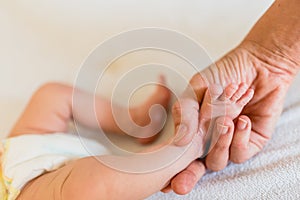 Mommy grabbing the little feet of her newborn daughter