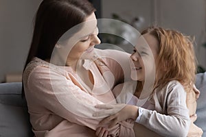 Caring foster mother embrace adopted child girl at living room photo