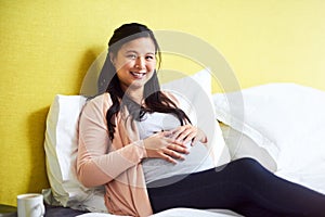 Mommy needs to relax while she can. Portrait of a pregnant woman relaxing at home.